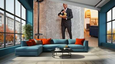 Respectable young african american man in black suit hold tray with double burger against gray wall. Wall mural