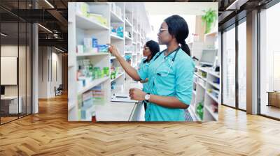 Two african american pharmacist working in drugstore at hospital pharmacy. African healthcare. Wall mural