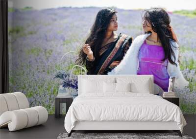 Two beautiful indian girsl wear saree india traditional dress in purple lavender field. Wall mural