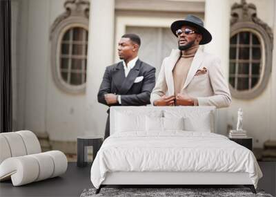 Two fashion black men. Fashionable portrait of african american male models. Wear suit, coat and hat. Wall mural