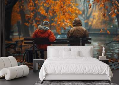 Two men sitting on a park bench in autumn weather Wall mural