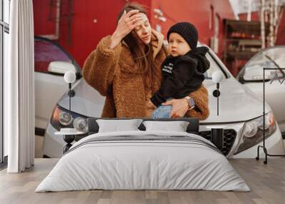 Young mother and child stand near they suv car. Safety driving concept. Wall mural