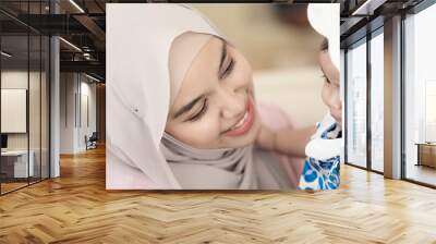 Asian Muslim mother woman hugging a  baby in her arms. family concept. Wall mural