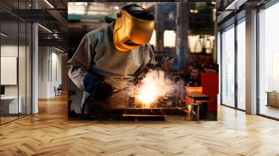 Industrial welder is welding metal part in the factory. Wall mural