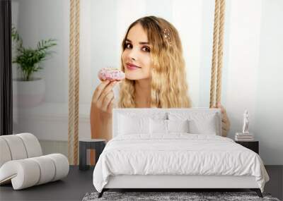 Young smiling woman holding donut Wall mural