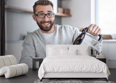 attractive man pouring himself a Cup of morning coffee Wall mural