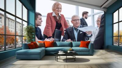 Businessman is reading contract in modern office Wall mural