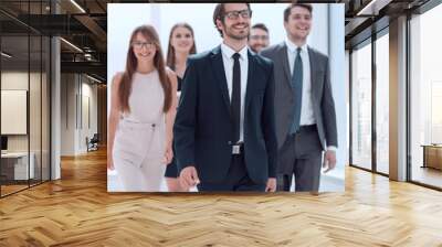 businessman walking in front of his business team Wall mural