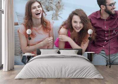 cheerful friends laughing in the living room. Wall mural