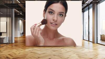 Close-up of a beautiful woman with a make-up brush Wall mural