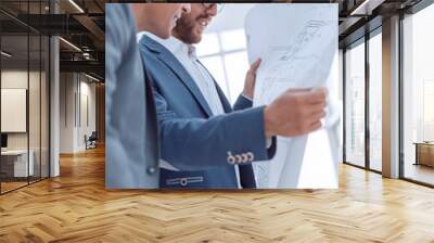 close up. smiling architect with blueprint standing in office Wall mural