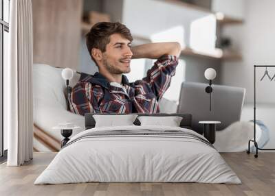 close up. successful young man sitting in front of an open laptop Wall mural