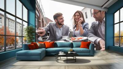 colleagues discuss new information at a table in a cafe Wall mural