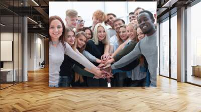 diverse young people putting their hands together Wall mural