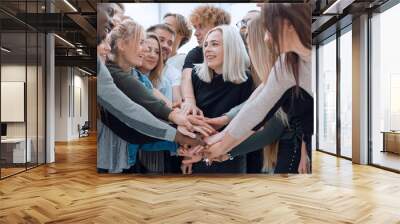 diverse young people putting their hands together Wall mural