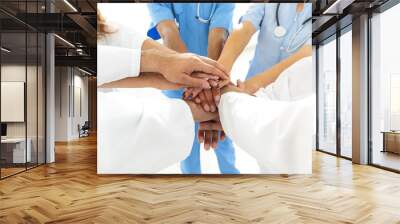 Doctors and nurses in a medical team stacking hands Wall mural