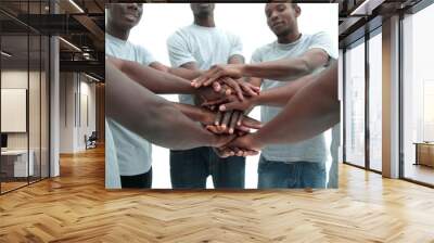 group of diverse guys making a tower out of hands Wall mural