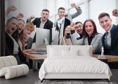 group of happy office employees sitting at a table. Wall mural