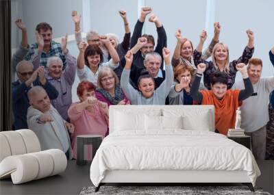 group of mature friends raised their hands up and celebrate succ Wall mural