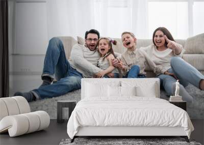 happy family sitting on the carpet in the living room Wall mural