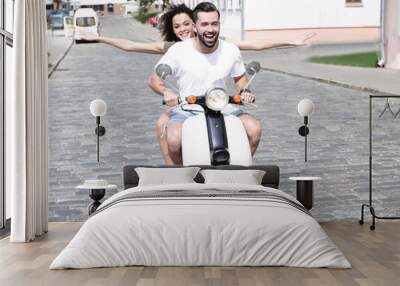 Happy young couple having fun on a scooter Wall mural