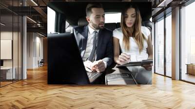 man and woman discussing work documents in taxi Wall mural