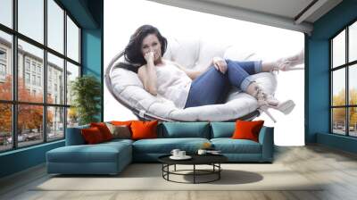 modern young woman relaxing in a round cozy soft chair. Wall mural