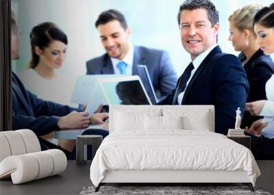 Portrait of business man smiling during meeting with colleagues Wall mural