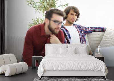 Portrait of two web designers discussing a project in front of a laptop Wall mural