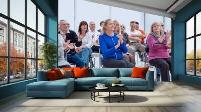 Smiling happy retirees studying. Many elderly in the conference room. Wall mural