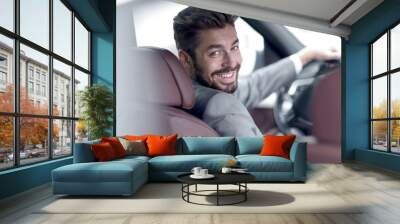 Successful man sitting behind the wheel of a prestigious car Wall mural