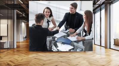 Successful young man smiling and handshaking with businessman Wall mural