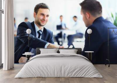 Two business colleagues shaking hands during meeting Wall mural