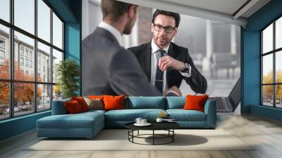 two businessmen discussing information from a laptop. Wall mural