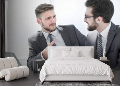 two businessmen talking, sitting at his desk Wall mural