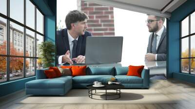 Two businessmen working on a laptop in the office Wall mural