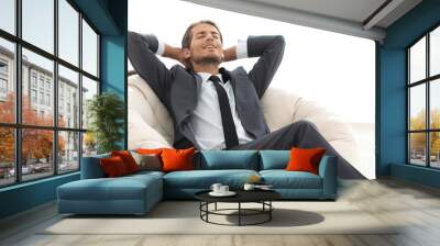 young businessman meditating in big comfortable armchair Wall mural