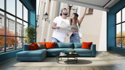 Young tourist couple with map looking for a way Wall mural