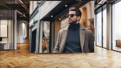 handsome young man in sunglasses looking away while walking on city street Wall mural