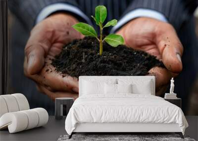 A man is holding a small plant in his hands. Generate AI image Wall mural