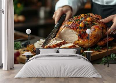 Close-up of a chef carving a roasted turkey on a wooden cutting board, surrounded by roasted vegetables and fresh herbs. Wall mural