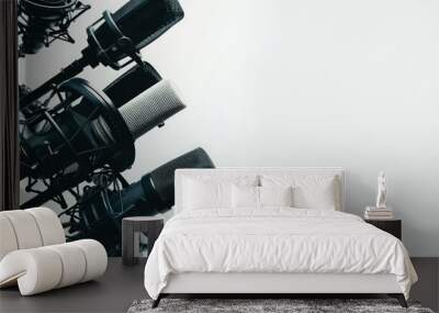 This close-up view captures the essence of an empty podcast studio, showcasing professional microphones and equipment arranged neatly against a pristine white background. Wall mural