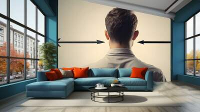 Man viewing two arrows pointing in opposing directions from the back. idea of a life's direction, goal, and choice. Wall mural