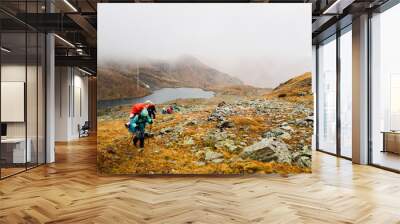 Tourists travelers with backpacks climb the rocks in dense fog. Poor visibility and easy to get lost. Caucasus Mountains, Arkhyz Wall mural