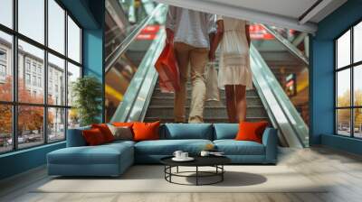 Cropped image of a couple walking down stairs in a modern shopping mall after a successful shopping trip, carrying shopping bags and enjoying a day out together in a stylish retail environment Wall mural