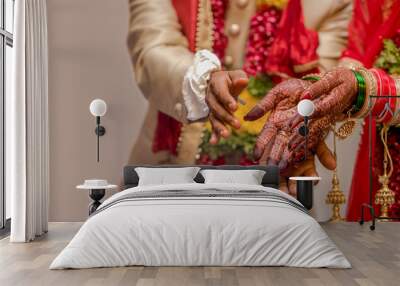 Very beautiful photo of a newly married Indian couple in ethnic attire offering flowers to God and taking blessings. Bride hands are decorated with henna design and colorful nuptial bangles. - Image. Wall mural