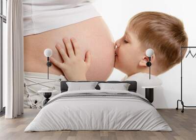 Young boy is kissing the pregnant woman Wall mural