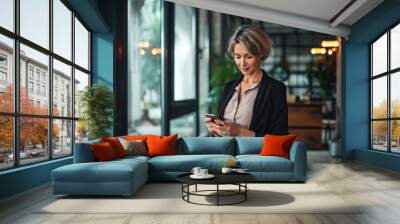 Busy mature elegant business woman model or mid age holding smartphone looking at cellphone standing in office. Middle aged female executive using cell phone digital tech device, Generative AI  Wall mural