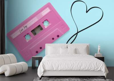 pink audio cassette tape with label tag love song tangled tape ribbon heart shape isolated on blue background, top view. Wall mural