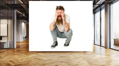 Adult redhead man sitting on the floor isolated Wall mural